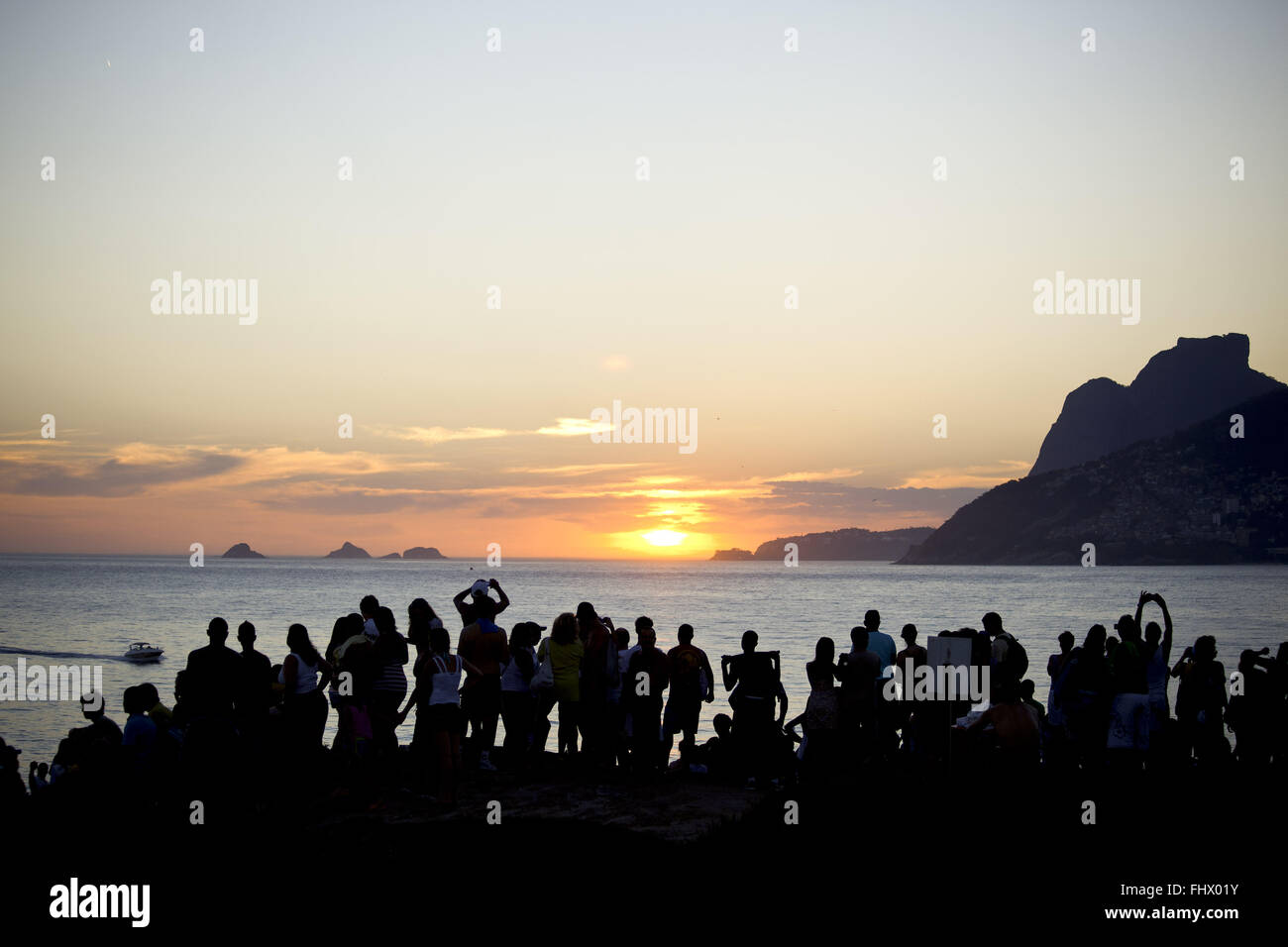 Touristen, die Betrachtung der Sonnenuntergang im Arpoador Rock mit Pedra da Gávea Recht Stockfoto