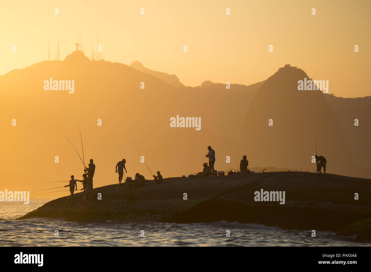 Fischer auf den Felsen zwischen den ozeanischen Stränden Ruhe und Camboinhas Stockfoto