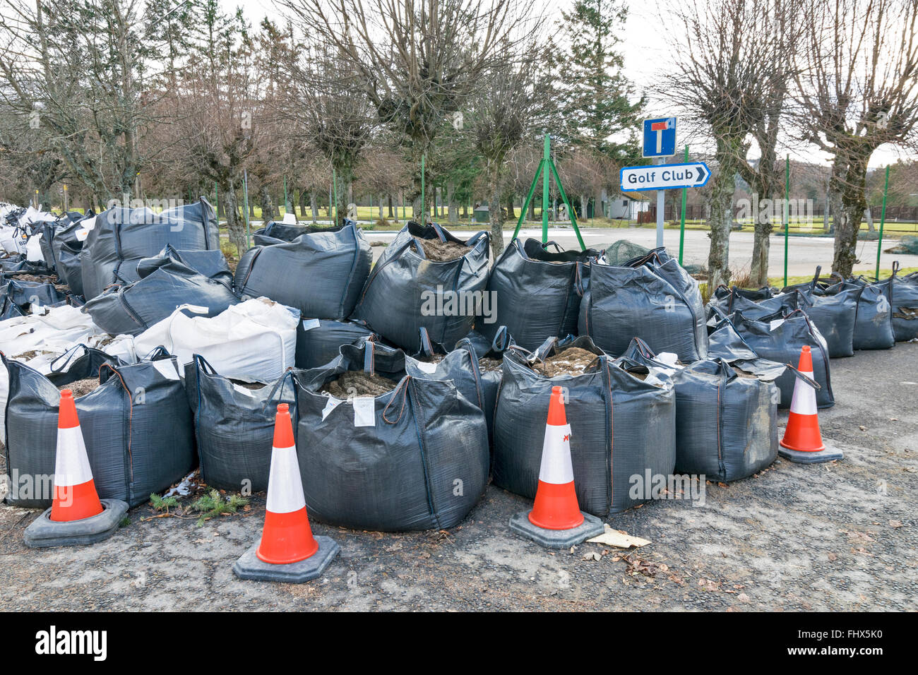 BALLATER ABERDEENSHIRE RIVER DEE HOCHWASSER SCHÄDEN GROßE SCHWARZE SÄCKE MIT SAND AUF EINER STRAßE AUßERHALB DES GOLFPLATZES Stockfoto