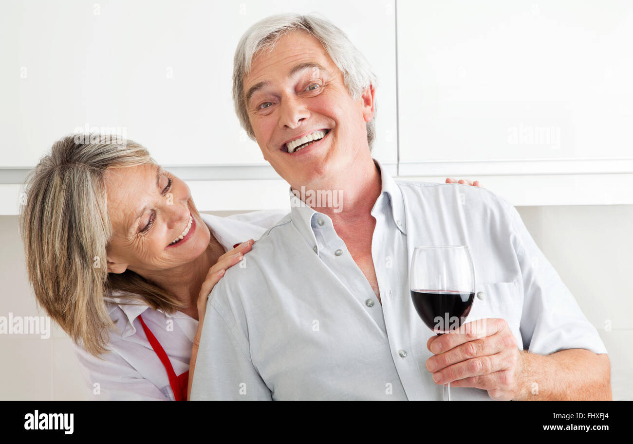Gerne älteres Paar mit Glas Rotwein Stockfoto