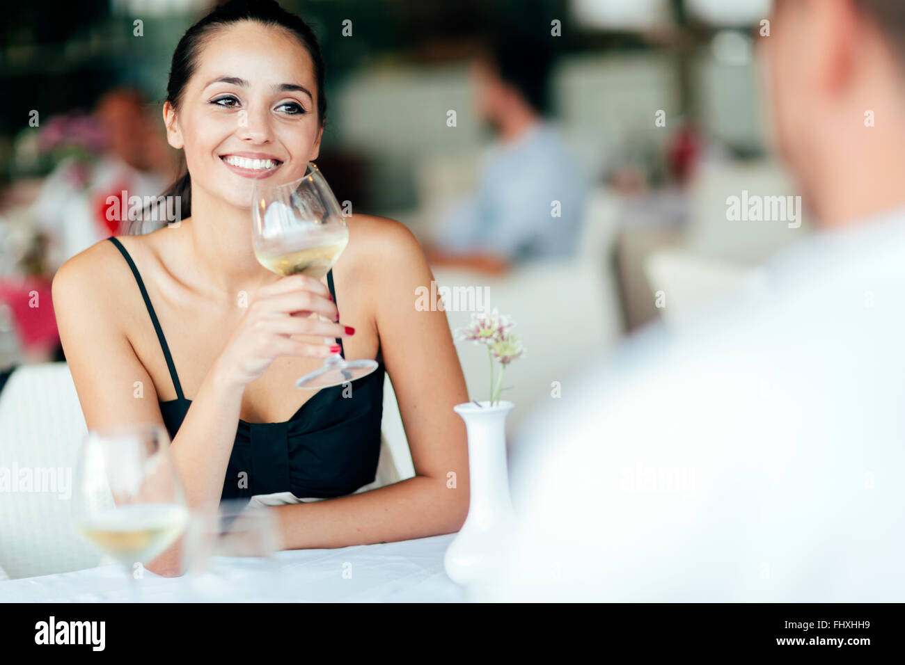 Paar im Restaurant feiern und mit einem Glas Weißwein Stockfoto
