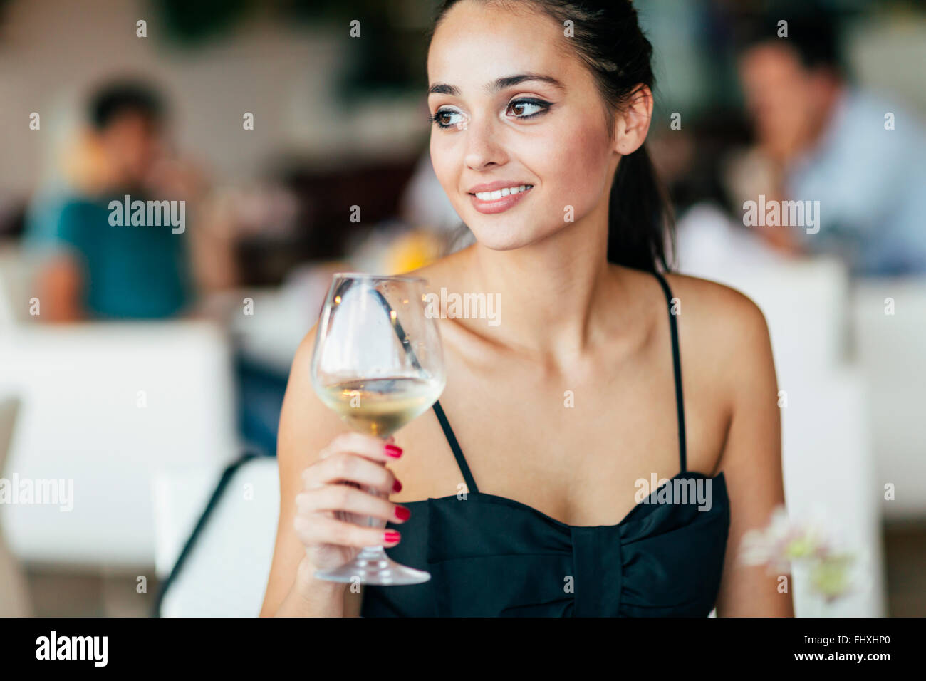Frau weiß Weinproben im Restaurant und Glas entsprechend anheben Stockfoto