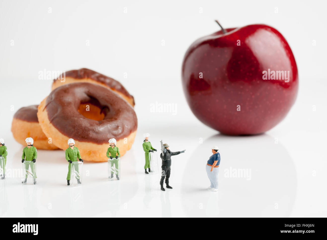 Winzige Bereitschaftspolizei erzählt einem dicken Mann auf einen Apfel statt Donuts Essen ein Übergewicht oder Kindermädchen Staat-Konzept Stockfoto