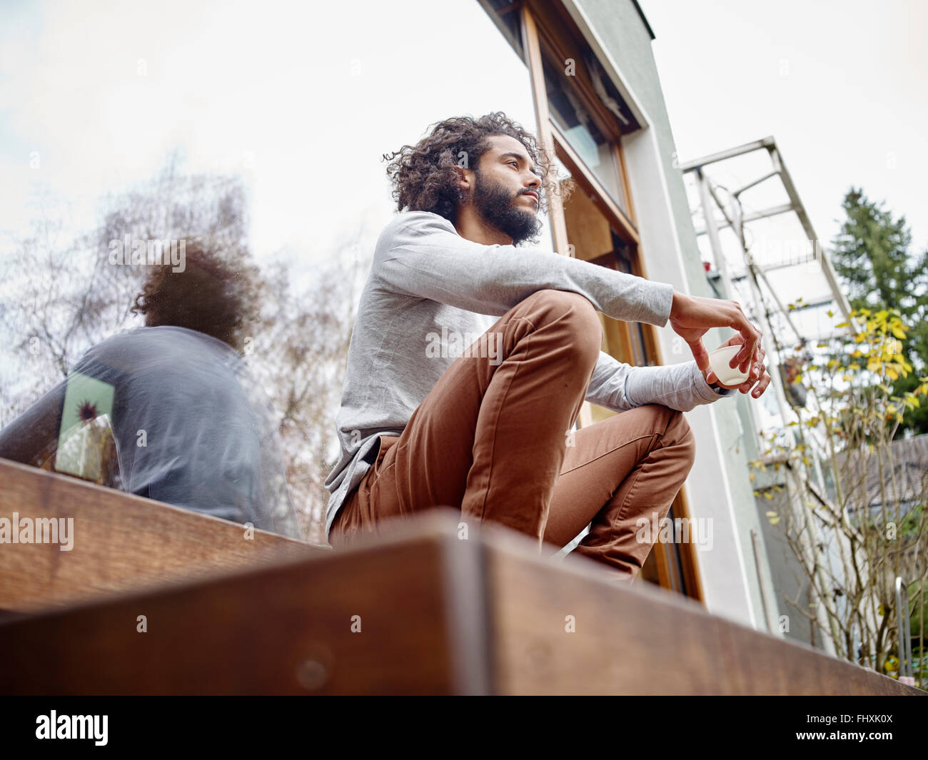 Junger Mann entspannend auf Terrasse Stockfoto