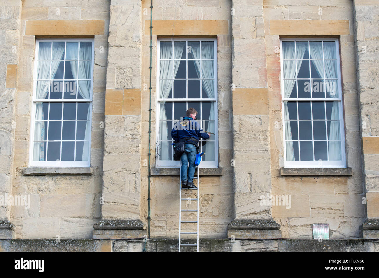 Fenster Reiniger Fensterputzen die The Guildhall, Chipping Norton, Oxfordshire, England Stockfoto