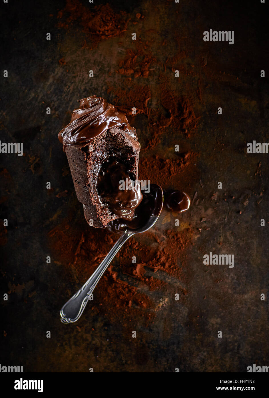 Schoko-Muffin mit flüssigem Kern, Kakao und Tee-Löffel Stockfoto