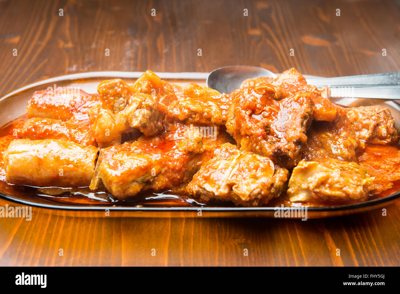Große Schüssel mit Fleisch in der Sauce auf den Holztisch Stockfoto