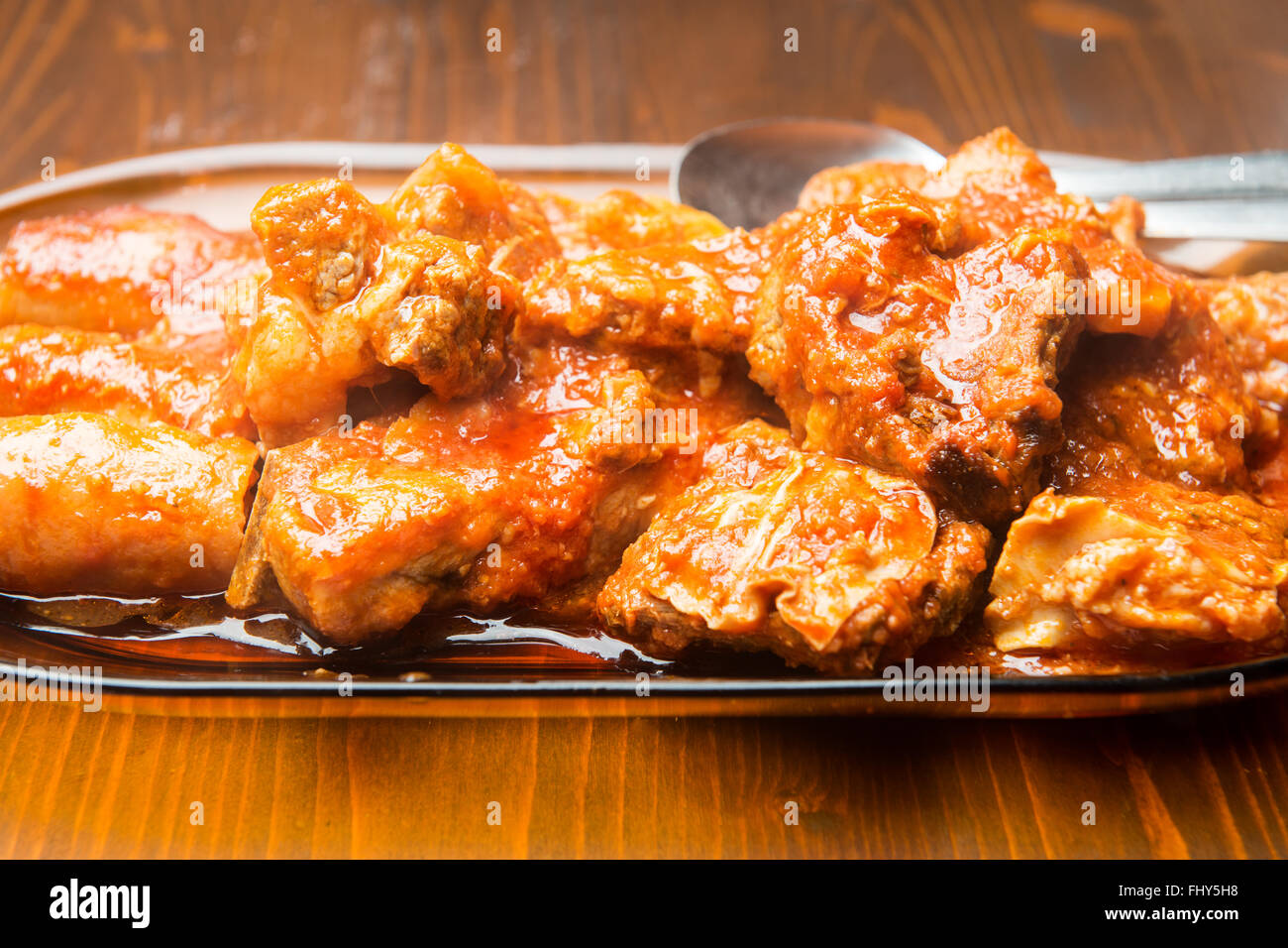 Große Schüssel mit Fleisch in der Sauce auf den Holztisch Stockfoto