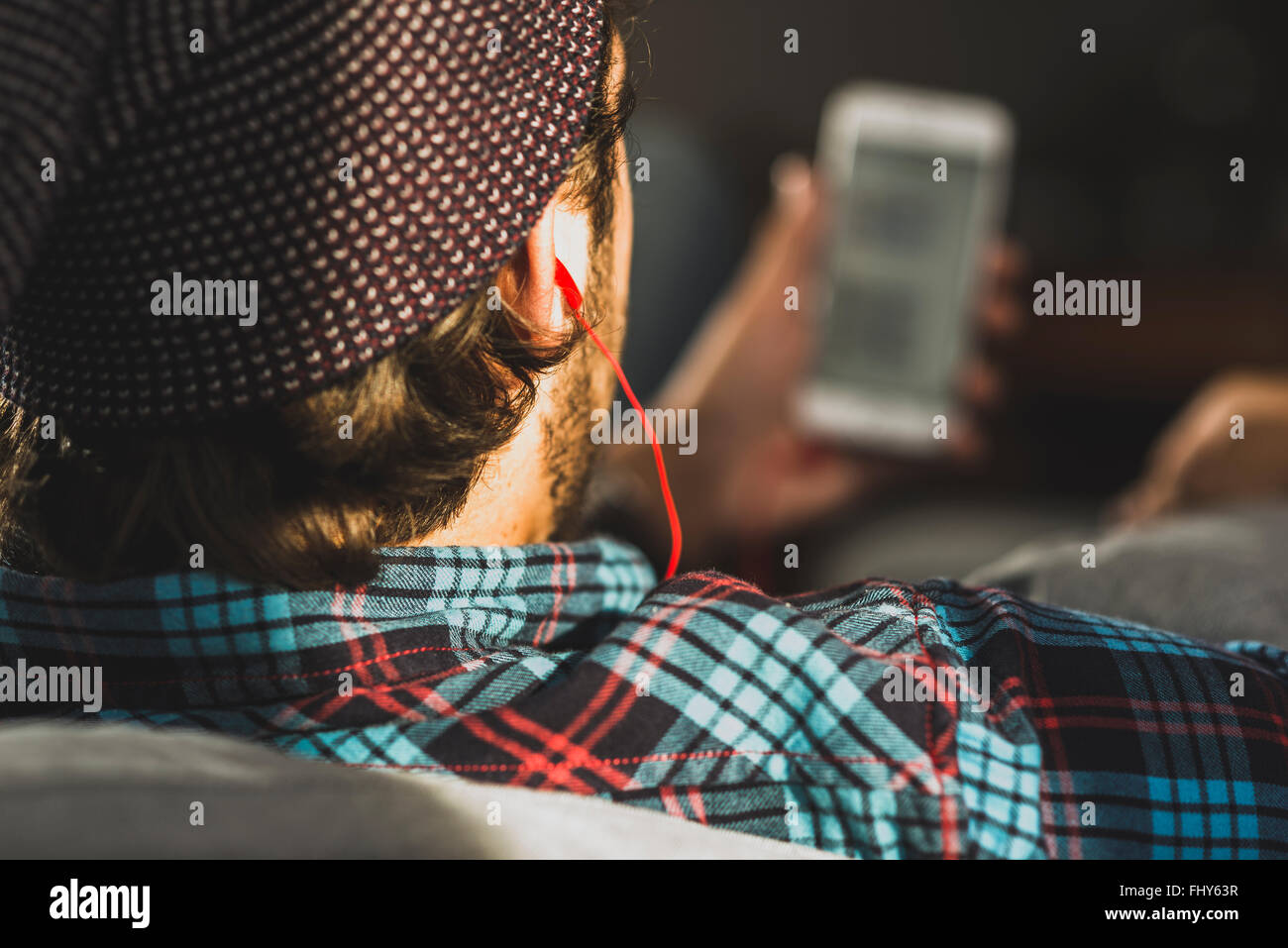 Rückansicht des Mannes hören von Musik mit Kopfhörern, Nahaufnahme Stockfoto