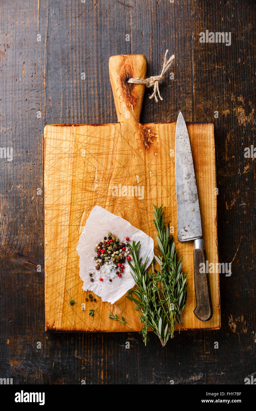 Chopping Board Küche Messer Gewürze und Rosmarin auf dunklem Holz Stockfoto