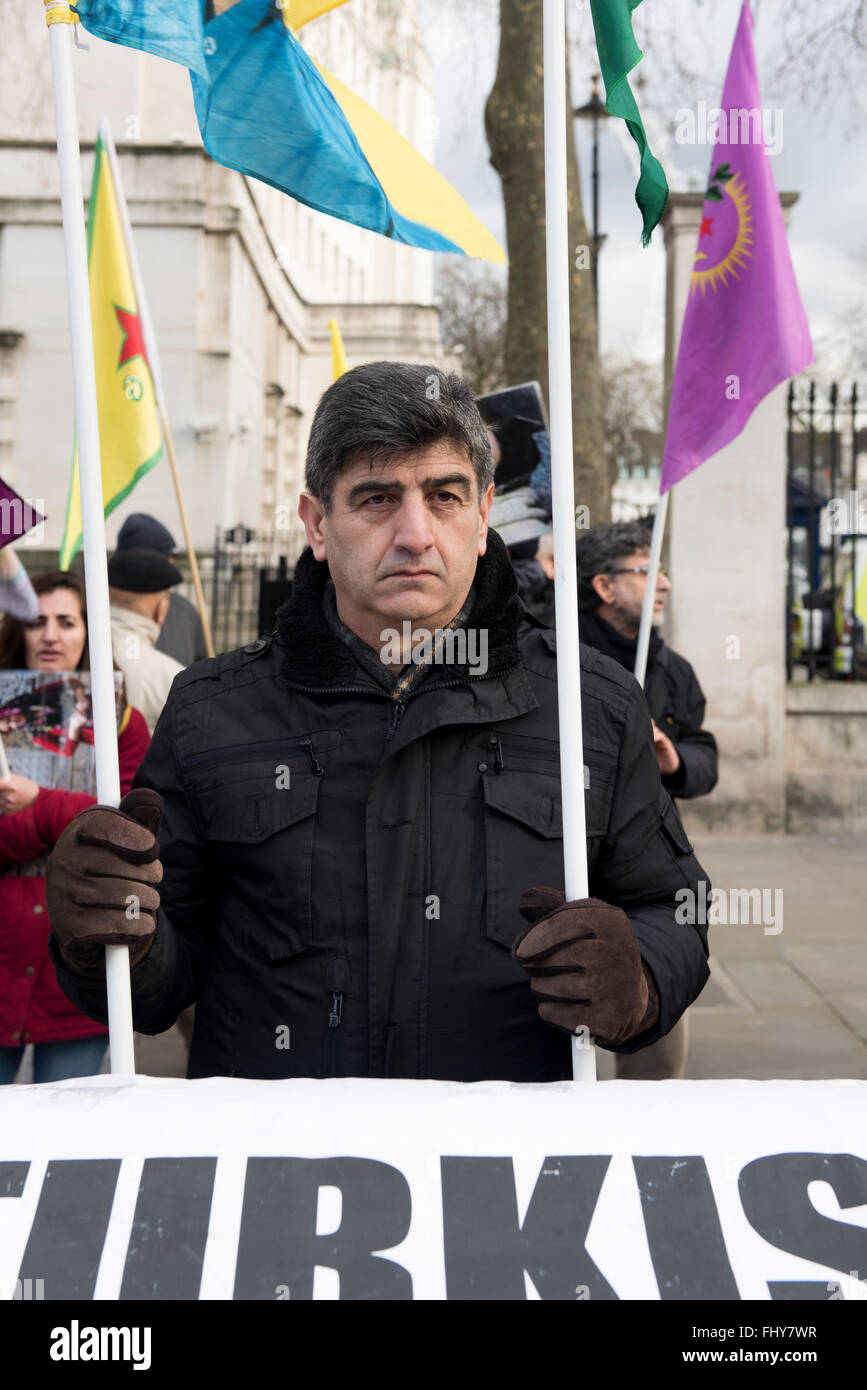 Mann hält zwei Flaggen während der kurdischen Demonstration außerhalb der Downing Street, London, UK. Stockfoto