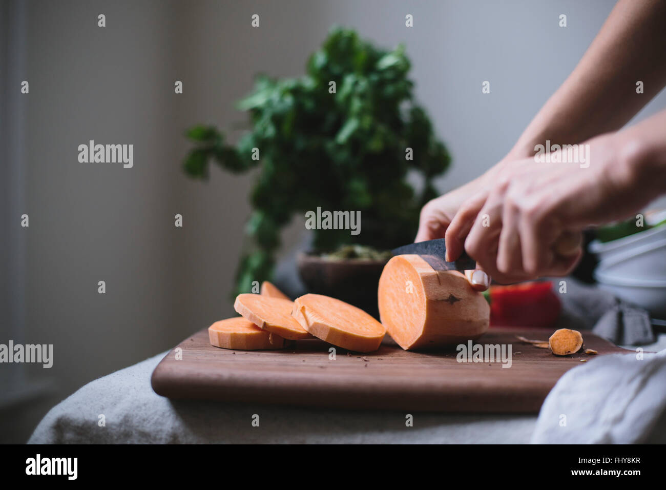 Eine Frau ist eine Süßkartoffel in einer Süßkartoffel Chili verwenden schneiden. Stockfoto