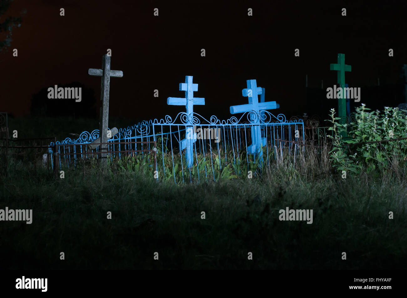 Alter Friedhof im Feld in der Nacht mit orthodoxen Kreuze Stockfoto