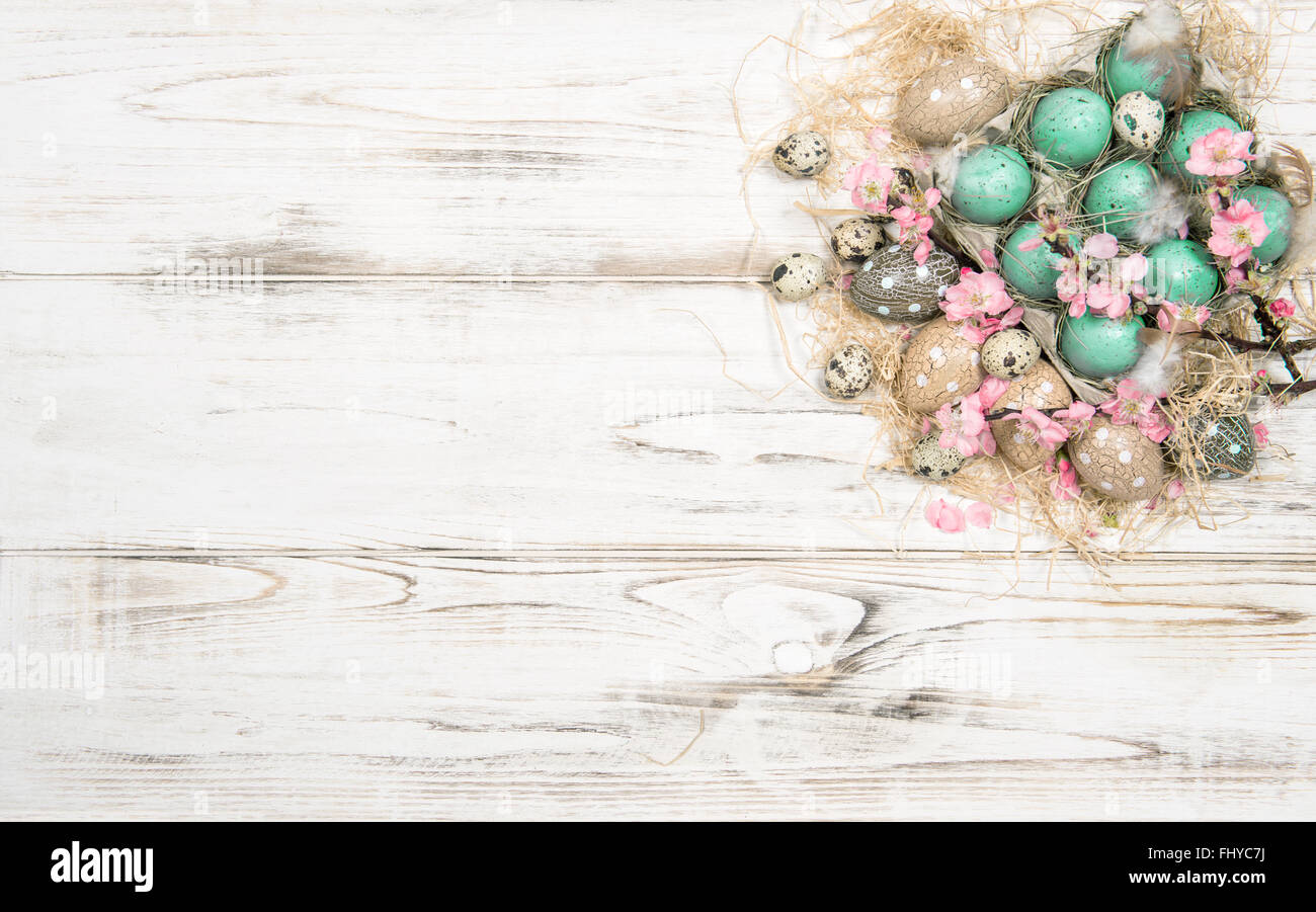 Oster-Deko mit Eiern und Blumen auf hellem Holz Hintergrund Stockfoto