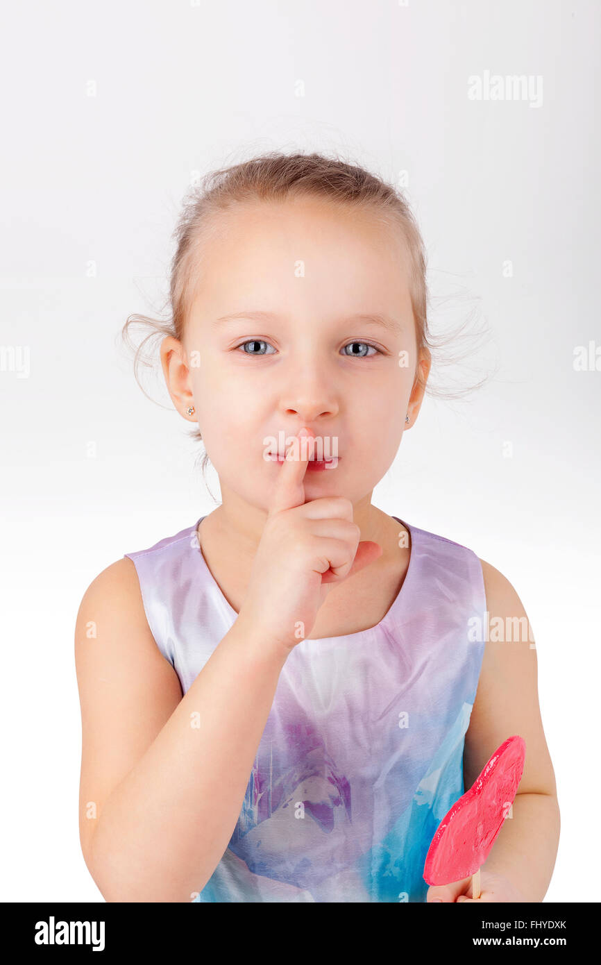 Zahnschmerzen. Kleines Mädchen mit Lutscher. Psst, ich liebe Süßigkeiten. Stockfoto