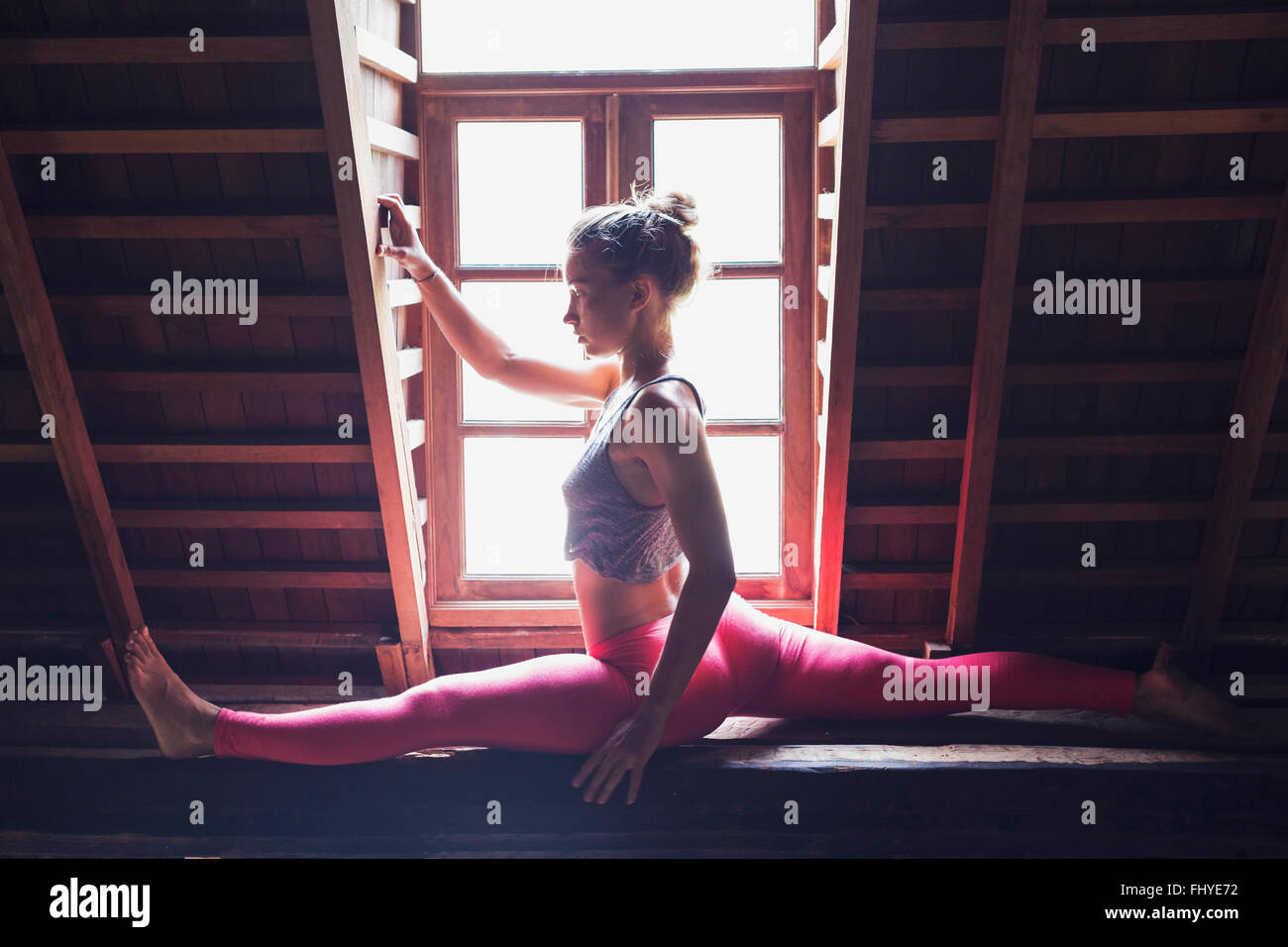 Frau in Yogaposition im Dachgeschoss Stockfoto