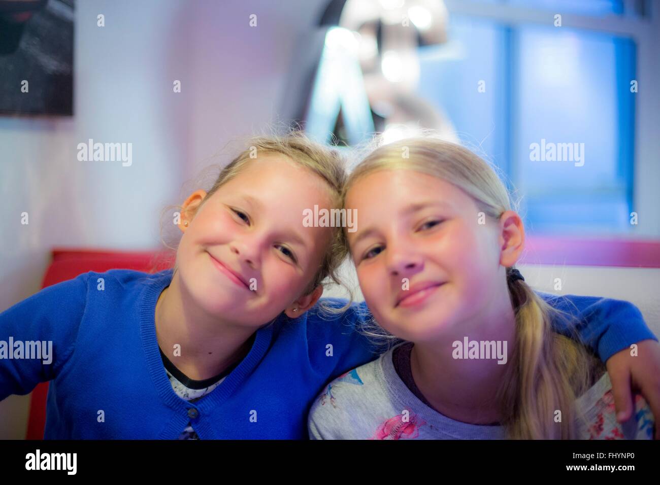 -MODELL VERÖFFENTLICHT. Zwei Mädchen lächelnd mit Arme umeinander. Stockfoto