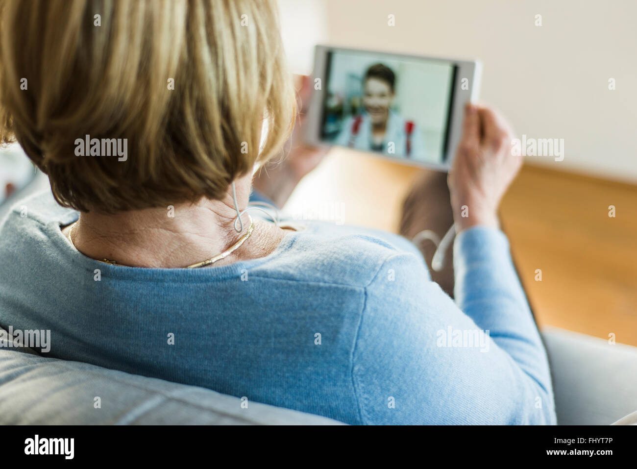 Ältere Frau betrachten Bild des jungen Mannes auf digital-Tablette Stockfoto