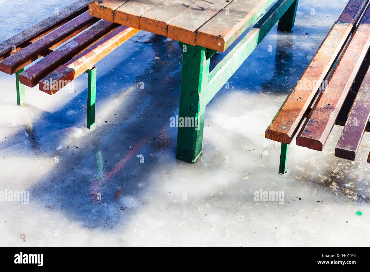 Gartentisch und Bänke in der Pfütze im Winter eingefroren Stockfoto