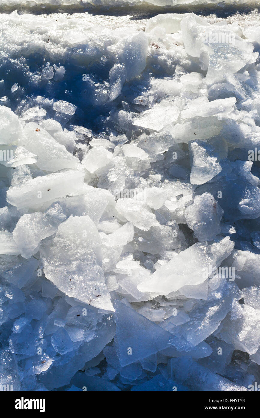 Eisblöcke in der Nähe von Eisloch im gefrorenen Fluss im winter Stockfoto
