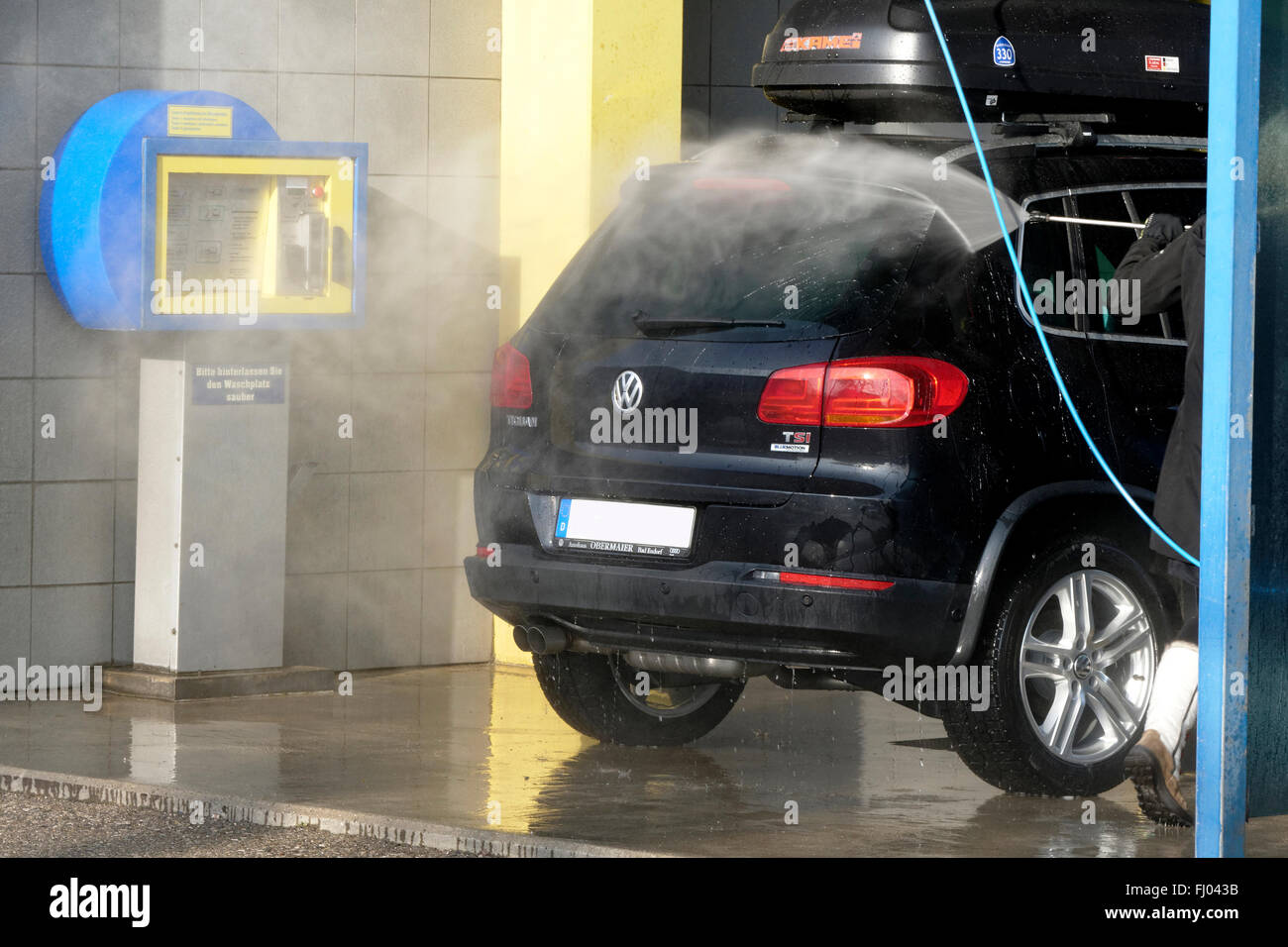 Person Reinigung VW Tiguan-Auto mit Wasser Druck Schlauch, Oberbayern, Deutschland Stockfoto
