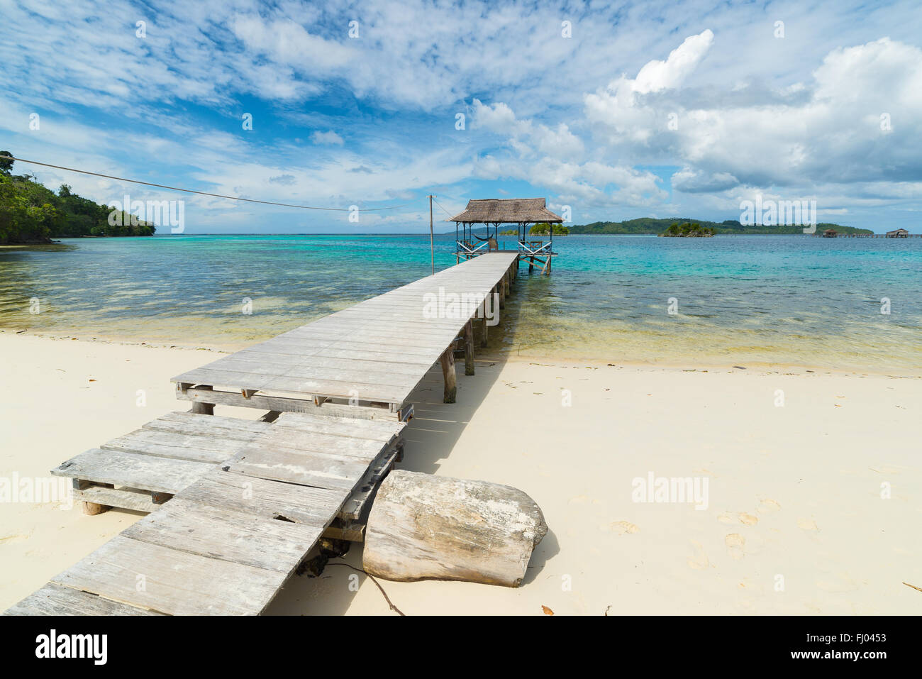 Hölzerne Steg überqueren malerische Türkis finden Sie im Ferienort auf einsamen Insel. Sommer-Abenteuer auf der abgelegenen Togian (Togean) I Stockfoto