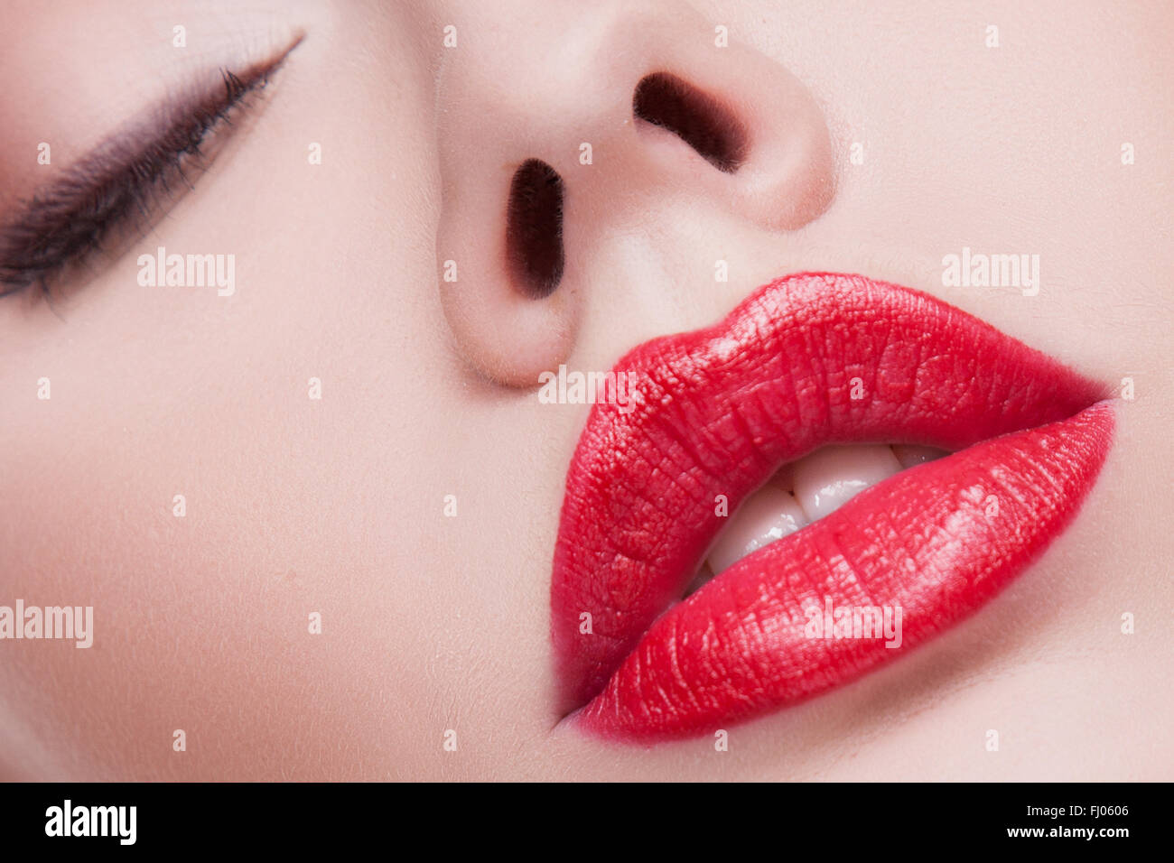 Red Lip Gloss oder Lippenstift. Feuchtigkeitsspendende Lipgloss rote Farbe, leichte Textur. Lippen close-up, Make-up, glitzernden Teilchen für das Volumen und die Schönheit der Lippen Stockfoto