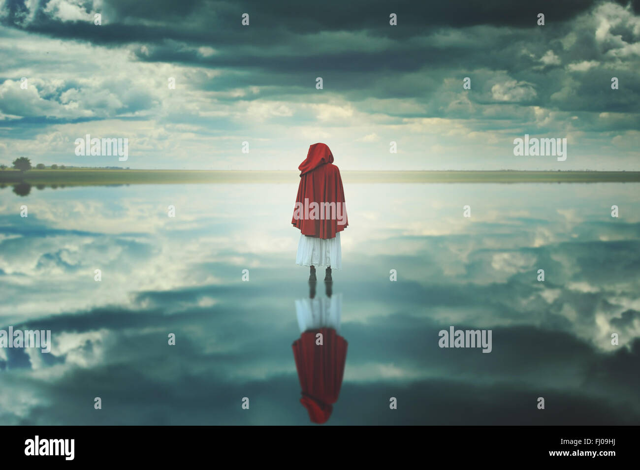 Rot mit Kapuze Frau in eine seltsame Landschaft mit Wolken. Fantasie und surreal Stockfoto