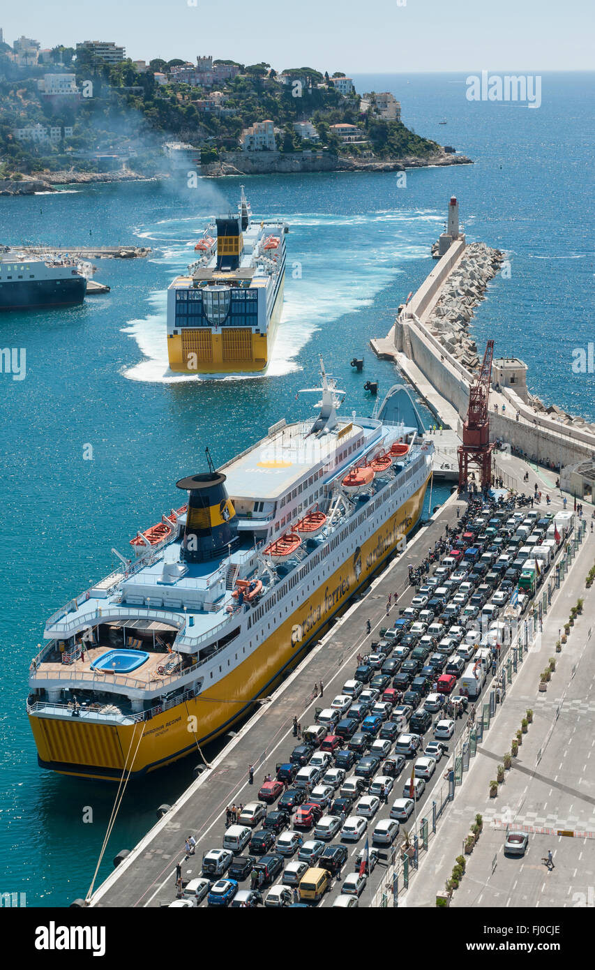 Zwei Korsika Fähren im Hafen von Nizza, Frankreich, eine js verlassen und ein anderer hat eine lange Schlange von Fahrzeugen warten auf Bord Stockfoto