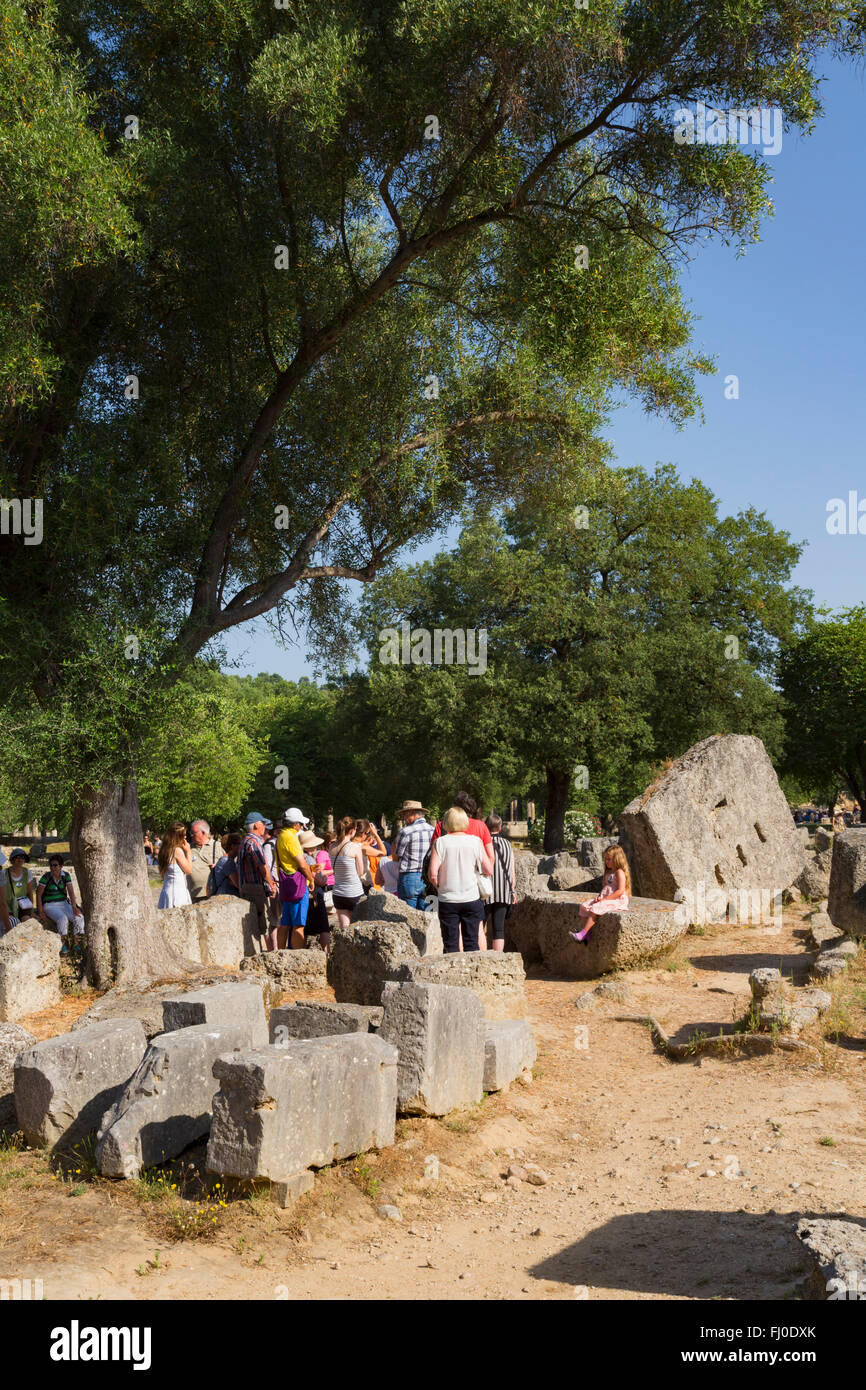 Olympia, Peloponnes, Griechenland.  Eine Gruppe von Besuchern eine Anleitung erklärt die Geschichte des antiken Olympia anhören. Stockfoto