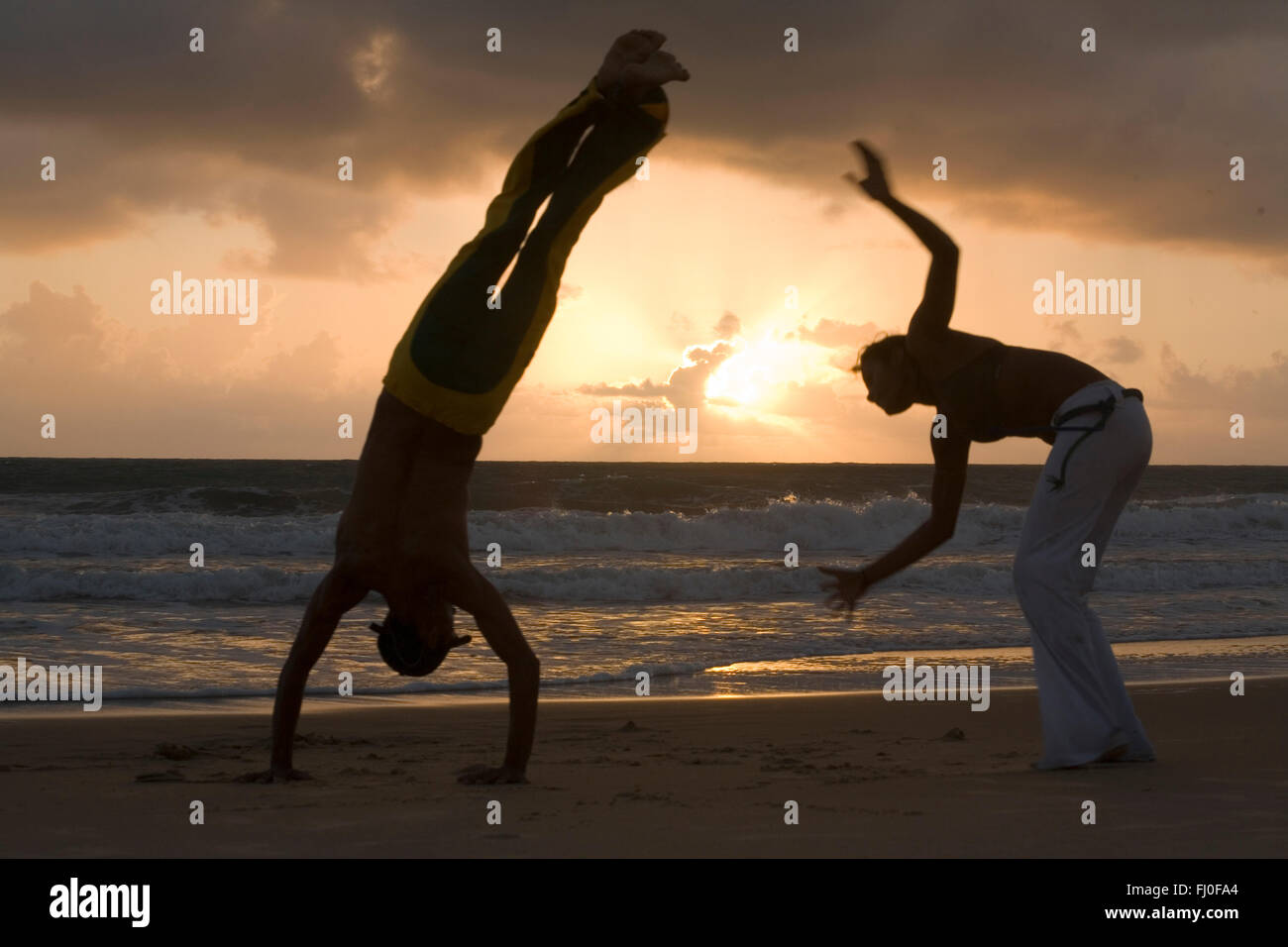 Capoeira, eine brasilianische Kampfkunst, die kombiniert Elemente aus Tanz, Akrobatik und Musik, und gekennzeichnet normalerweise als ein Spiel - bekannt für schnelle und komplexe bewegt, vor allem Kraft, Schnelligkeit und Hebel für eine Vielzahl von Tritte, Drehungen und hochmobile Techniken - am 26. November 2014 mit Capoeira erhielt einen besonderen Schutzstatus als "immaterielles Kulturerbe" von der UNESCO. Strand von Ponta Negra, Stadt Natal, Rio Grande Norte, Brasilien. Stockfoto