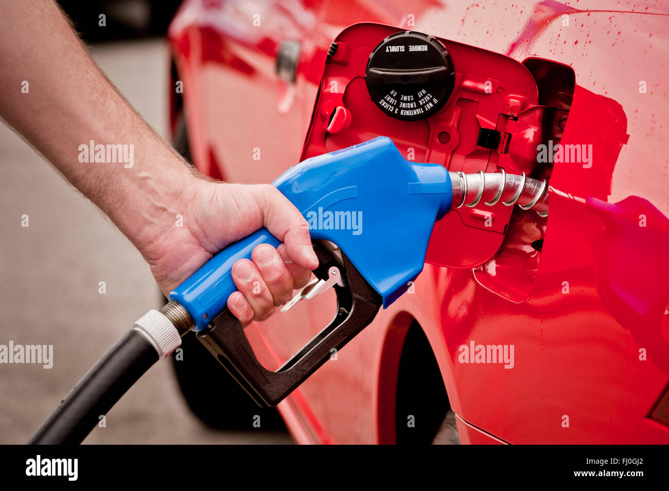 Blau Benzin Düse In roten Auto Stockfoto