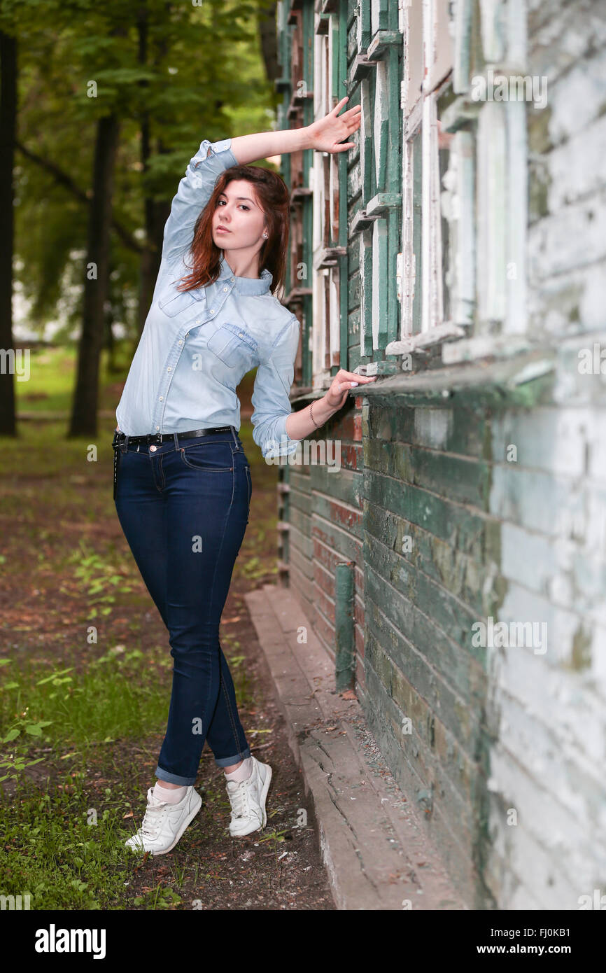 Studentin über einem verlassenen Haus im Park. Stockfoto