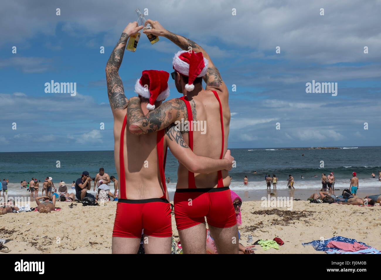 Männer Toasten ein frohes Weihnachtsfest am Coogee Beach, Sydney, New South Wales, Australien Stockfoto