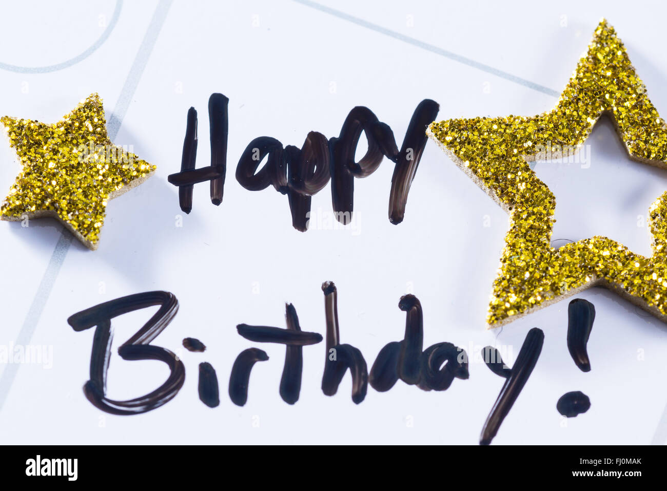 Nahaufnahme eines Kalenders mit dem Worte happy Birthday drauf geschrieben und dann mit goldenen Sternen verziert Stockfoto