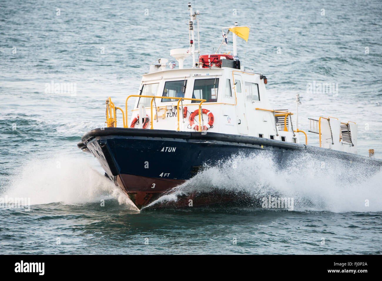 Panamakanal Pilot Boat Panama // PANAMAKANAL, Panama — Ein Pilot-Boot setzt einen Piloten zu einem Schiff ab, das in den Panamakanal eindringt. Jedes Schiff, das die Wasserstraße durchquert, muss einen Panamakanal-Piloten an Bord haben, um das komplexe Schleusensystem zu steuern. Der 1914 eröffnete 50 km lange Kanal dient als wichtige Schifffahrtsstraße zwischen dem Atlantik und dem Pazifischen Ozean, wodurch Schiffe nicht mehr Südamerika umfahren müssen. Das technische Wunderwerk wurde von den Vereinigten Staaten bis zum 31. Dezember 1999 gebaut und betrieben, als die Kontrolle nach Panama unter den Bedingungen des 1977 Torr übertragen wurde Stockfoto