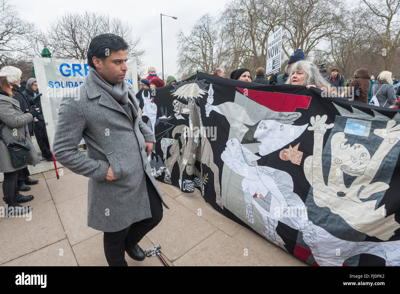 London, UK. 27. Februar 2016. Einer der Organisatoren des Marsches aus Hyde Park Corner, eine Kundgebung am Marble Arch am selben Tag als Proteste in anderen Städten in ganz Europa jetzt handeln Nachfrage öffnen sicheres Geleit Routen für alle Flüchtlinge und Asylbewerber, suchen Schutz in Europa Gespräche mit Aktivisten aus Brignton, die ein Banner erstellt haben basierend auf Picassos Guernica. Peter Marshall, Alamy Live-Nachrichten Stockfoto