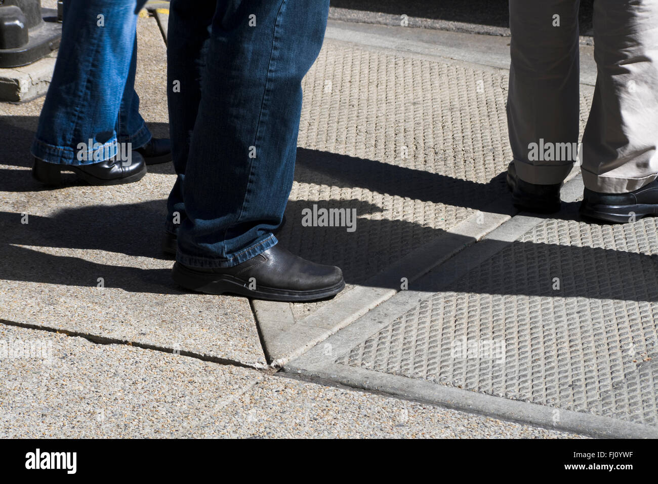 Sechs Beine auf Bürgersteig Stockfoto