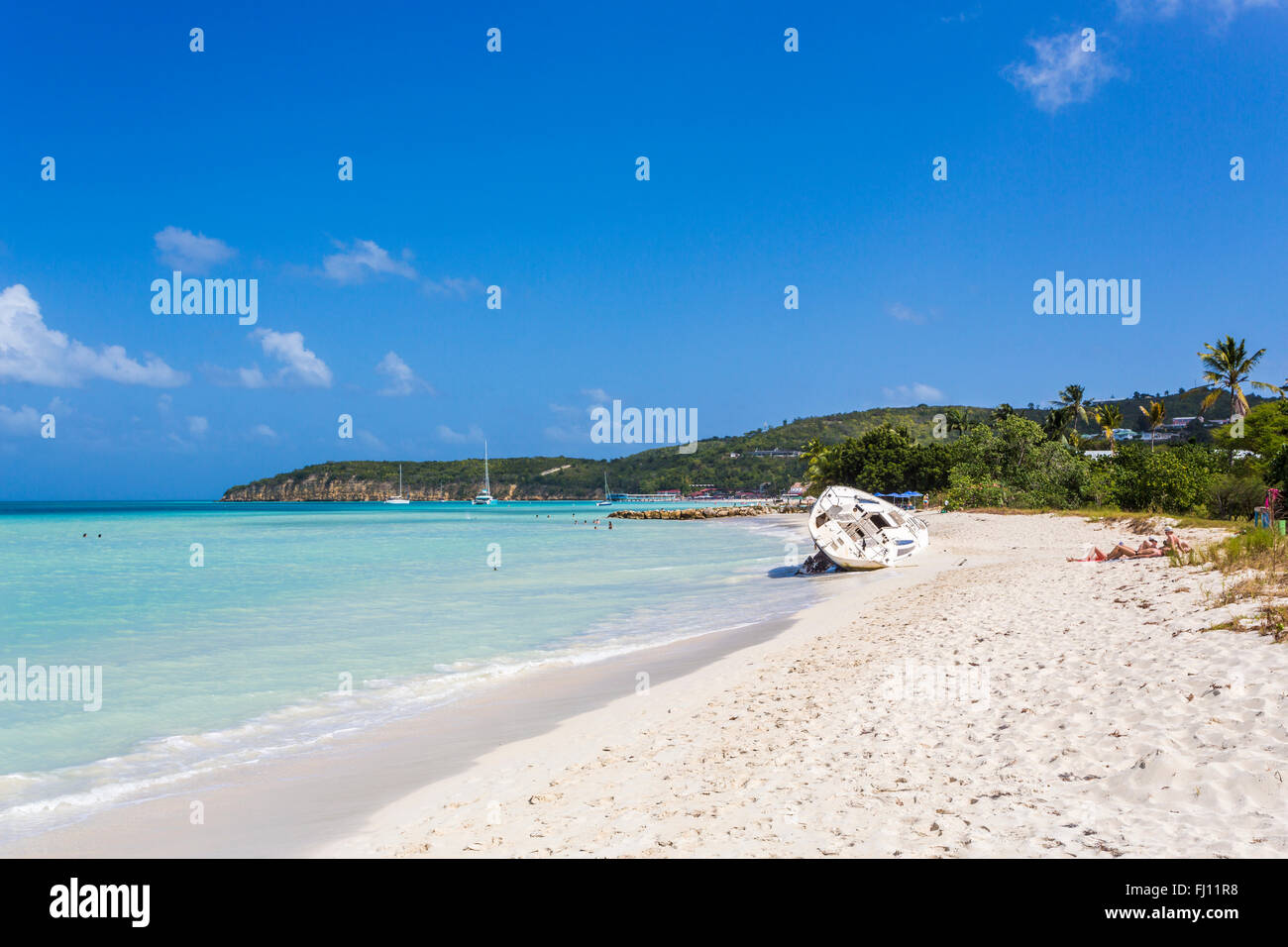 Havarierte Jacht aufgegeben am Strand in Dickenson Bay, North Antigua, Antigua und Barbuda, Westindien an einem sonnigen Tag, blauer Himmel Stockfoto