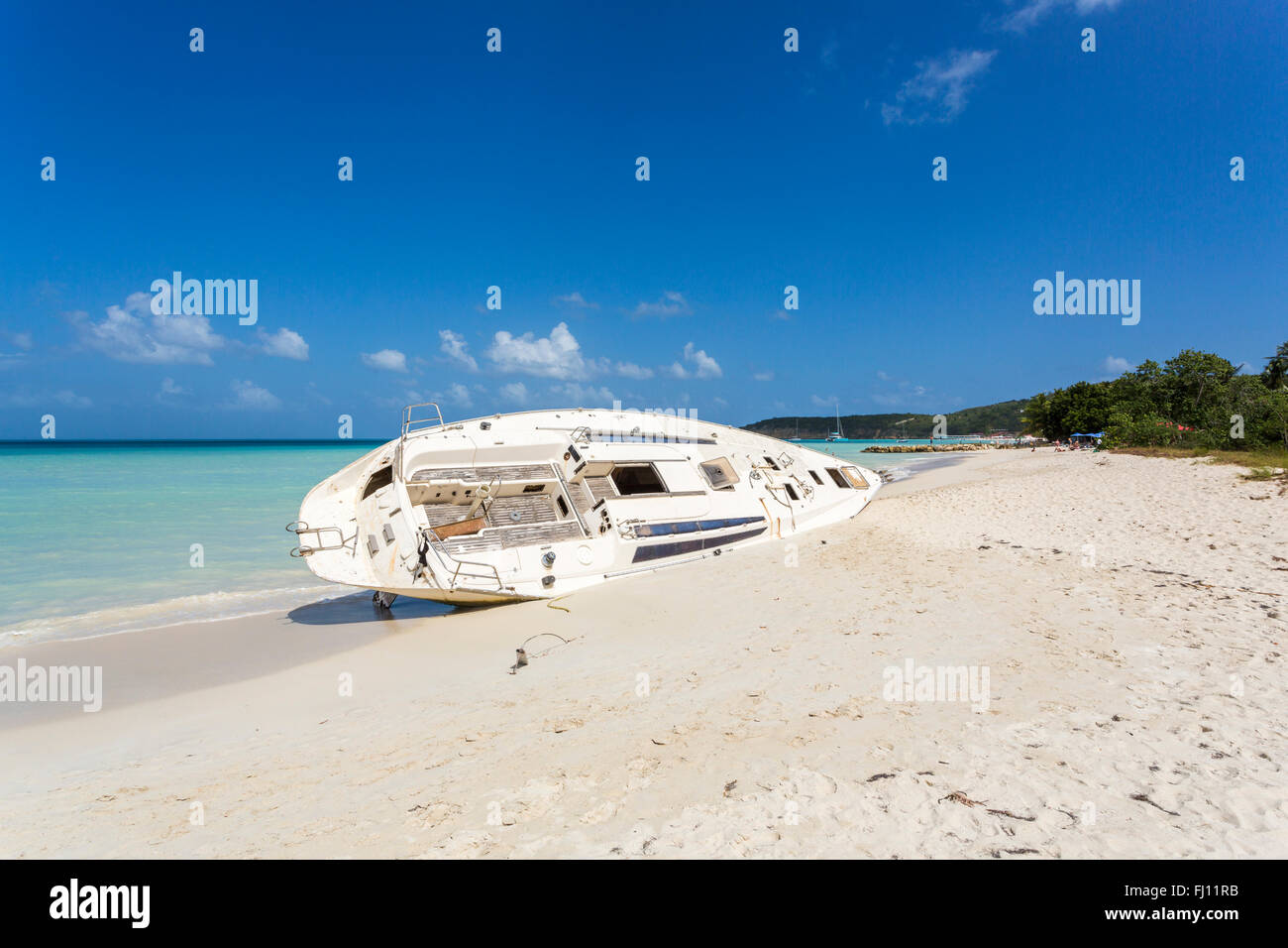 Havarierte Jacht aufgegeben am Strand in Dickenson Bay, North Antigua, Antigua und Barbuda, Westindien an einem sonnigen Tag, blauer Himmel Stockfoto