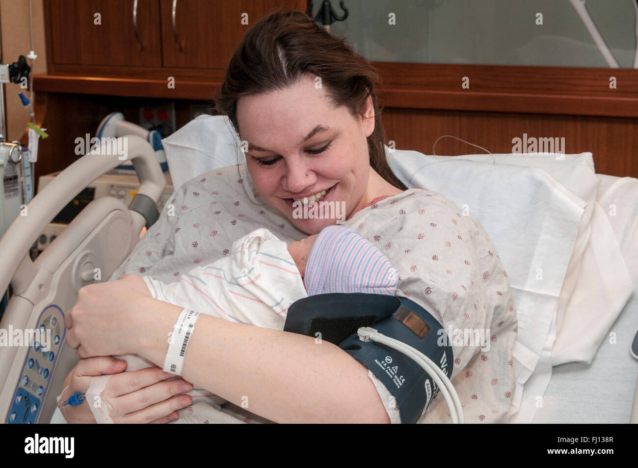 Fridley, Minnesota. Einheit-Krankenhaus. 31 Jahre alt, alleinerziehende Mutter Verklebung mit Bi-Rasse neugeborenes Mädchen im Krankenhaus. Stockfoto