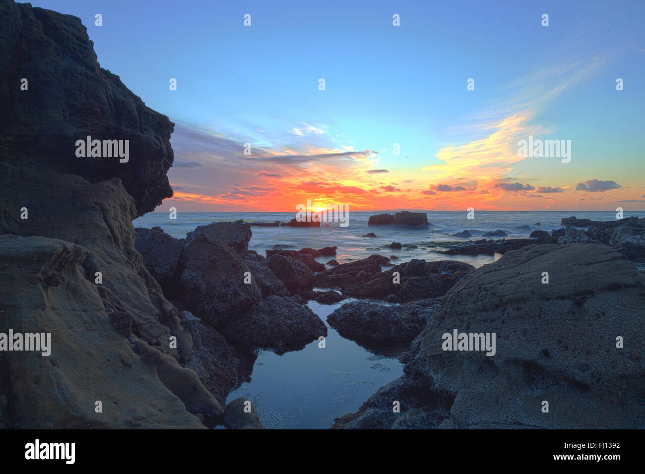 Langzeitbelichtung der Sonnenuntergang über Felsen, geben einen Nebel wie Effekt über Meer in Laguna Beach, Kalifornien, USA Stockfoto