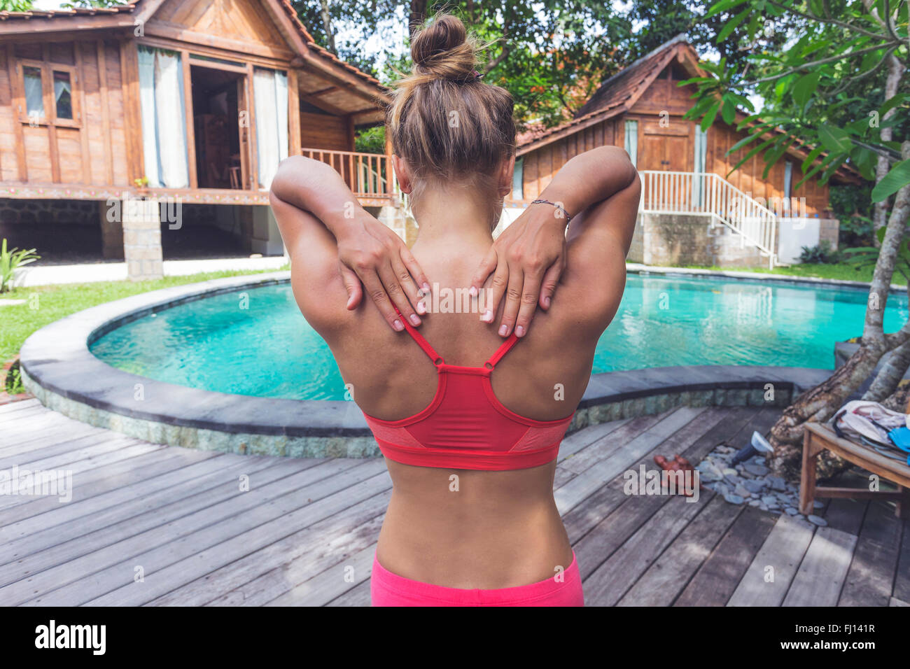 Indonesien, Bali, Frau praktizieren Yoga am Pool Stockfoto
