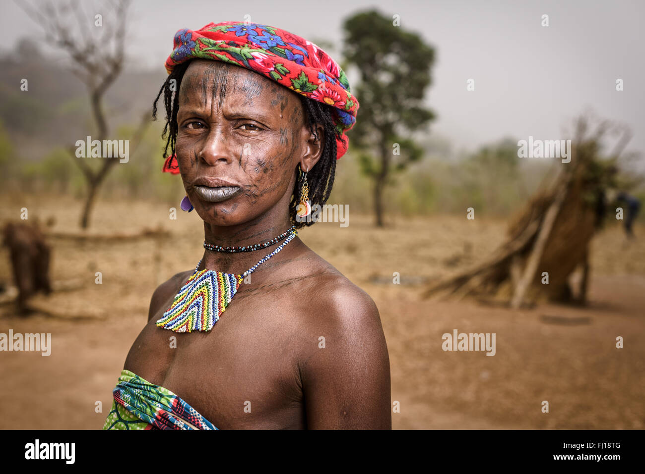 Porträt einer Frau Mbororo mit Narben auf ihrem Gesicht und dekorative Halskette außerhalb ihrer Hütte. Stockfoto