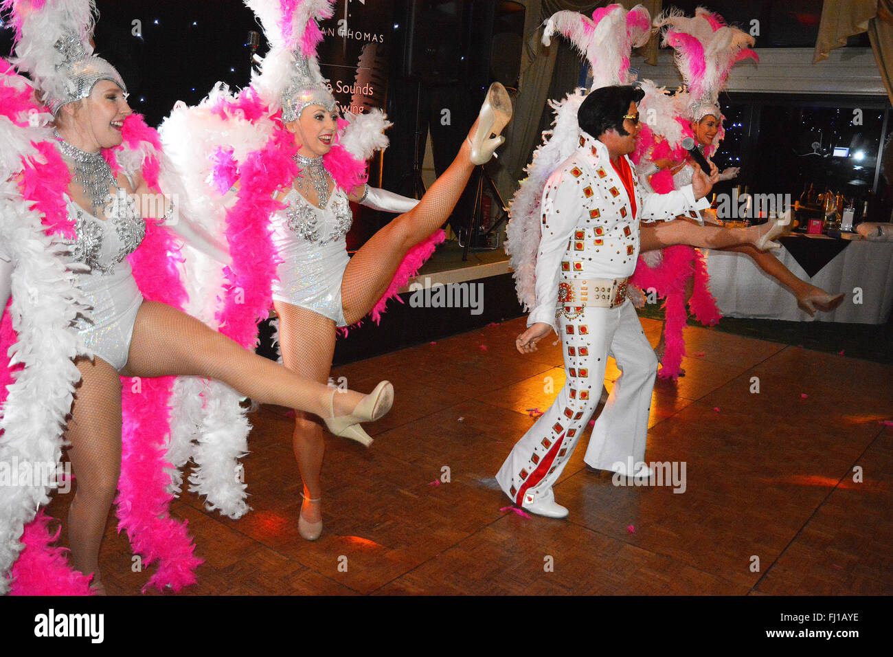 Elvis Tribute Sänger Mick Goodwill mit tanzenden Mädchen bei einem Charity-Nacht in Hinckley, Großbritannien. Stockfoto