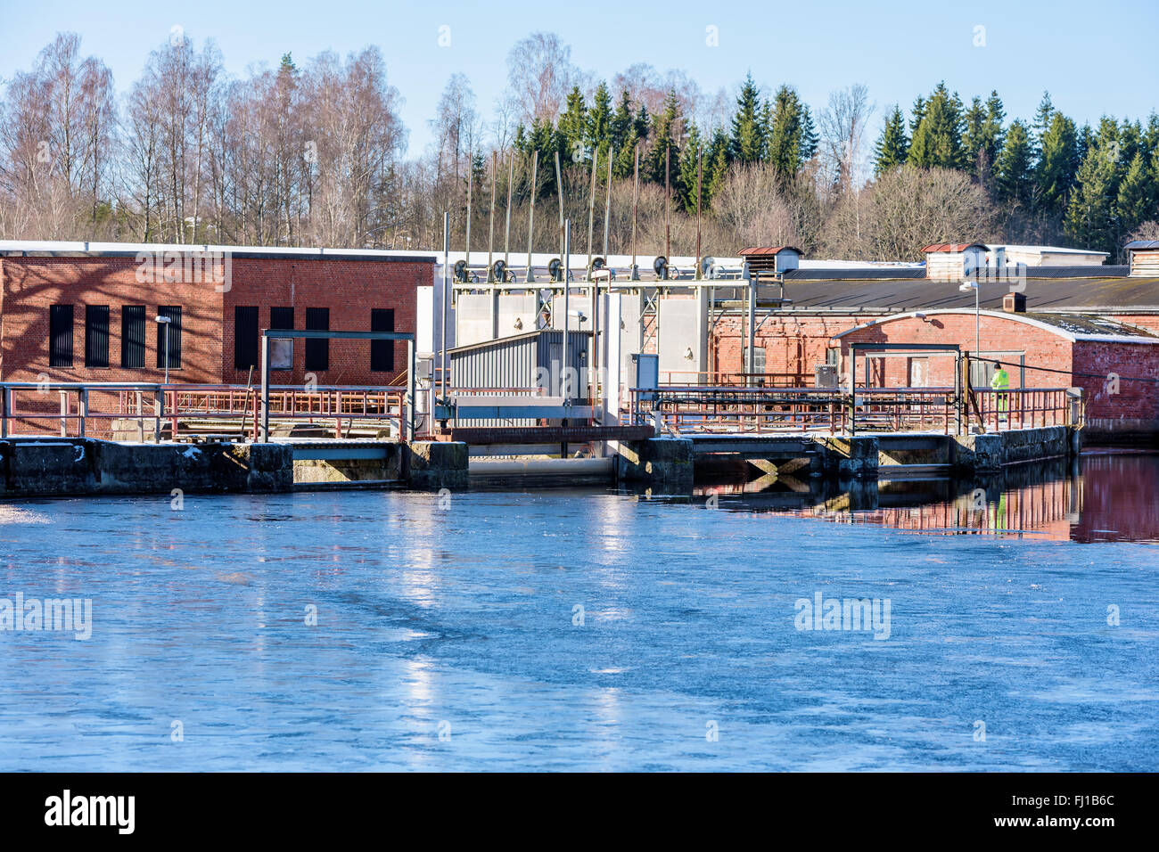 Fridafors, Schweden - 16. Februar 2016: Unbekannte Person, die einen Sicherheits-Check auf einer verlassenen Papierfabrik an der Brücke eines Dammes. Stockfoto
