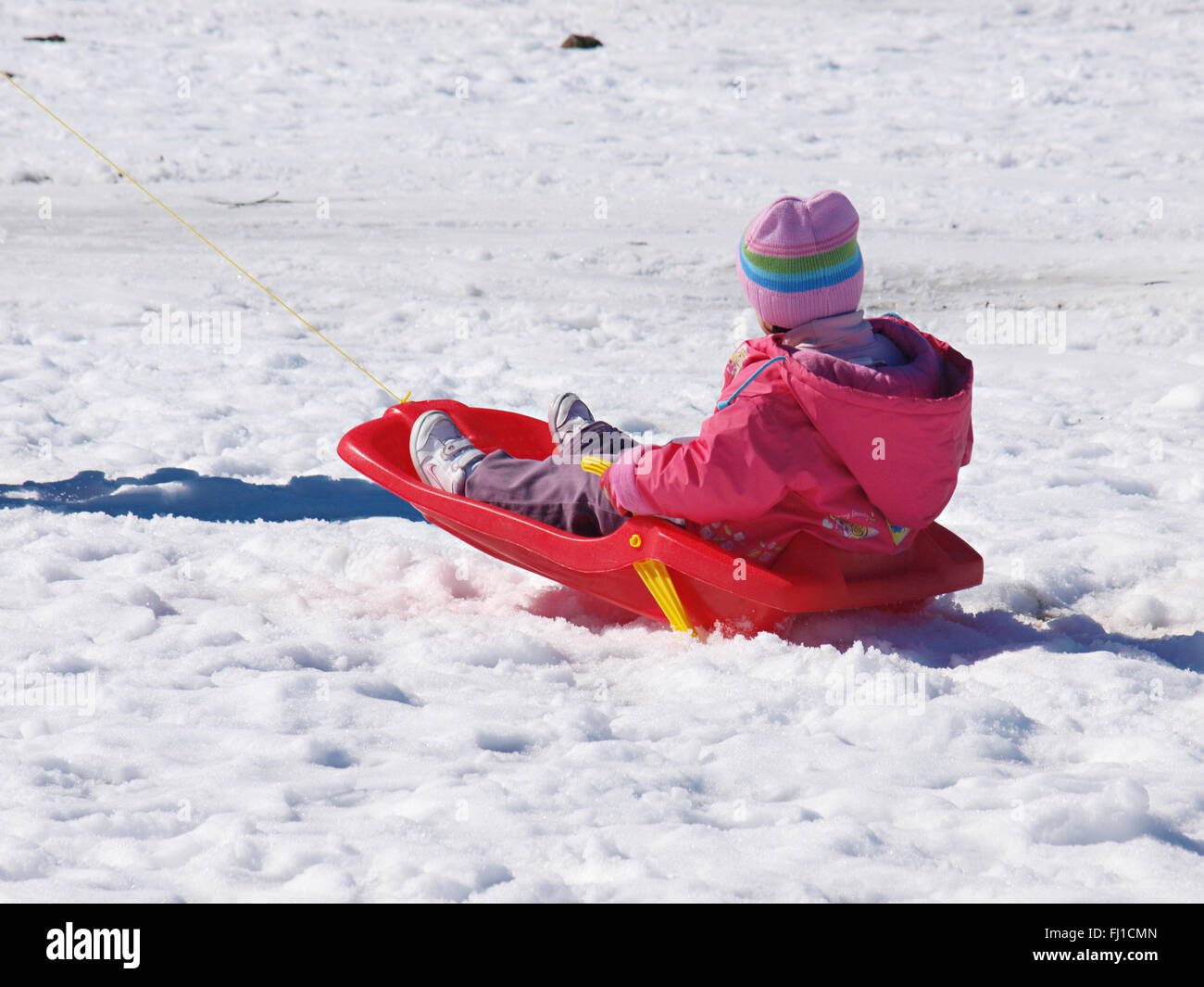 Kind auf Schlitten im Schnee im Teide-Nationalpark, Teneriffa Stockfoto