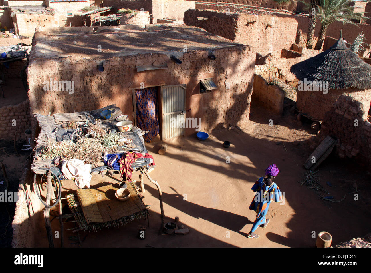 Eine Frau steht im Innenhof eines traditionellen Schlamm banco Haus in der Stadt von Bani, Burkina Faso Stockfoto