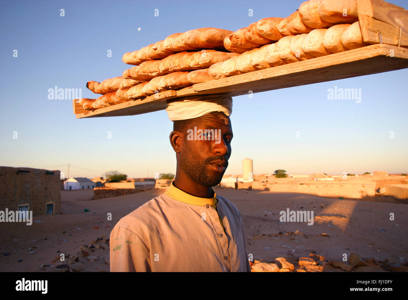 Chinguetti: der Mann, der den Verkauf von frischem Brot am frühen Morgen in der Stadt, Sahara, Mauretanien Stockfoto