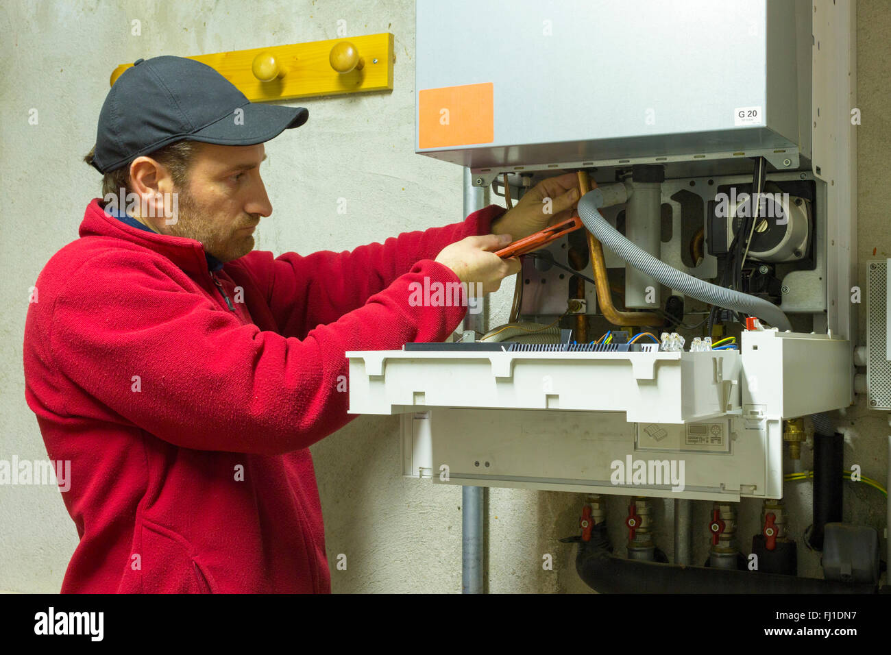 Klempner Reparatur eine Brennwert-Heizkessel im Heizraum Stockfoto